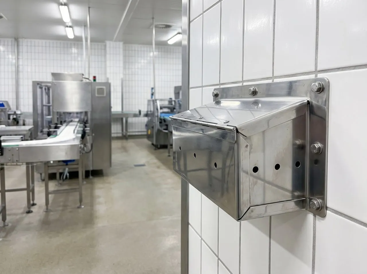 Stainless rodent monitoring station in a food processing facility